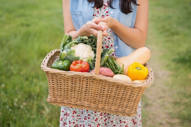 Mujer bonita con cesta de verduras