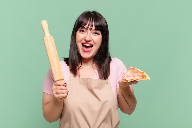 Mujer bonita chef sorprendida expresión y sosteniendo una pizza