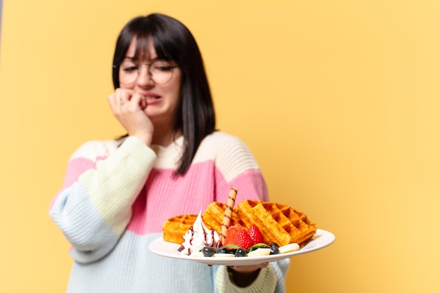 Foto mujer bonita comiendo gofres