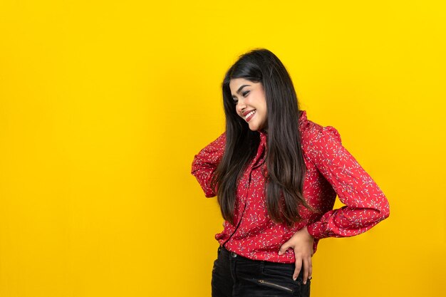 Mujer bonita curiosa con expresión alegre aislada sobre fondo amarillo