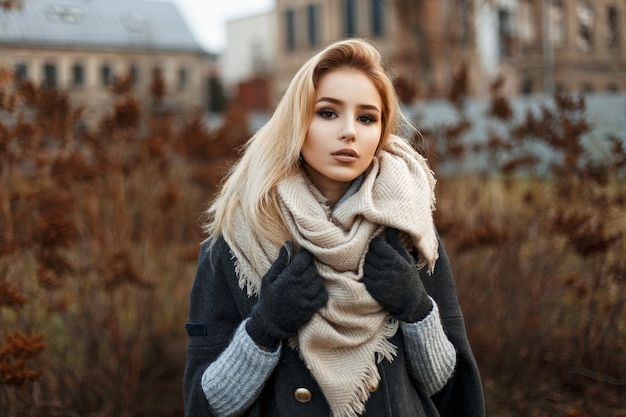 Mujer bonita en elegante bufanda de punto en día de otoño