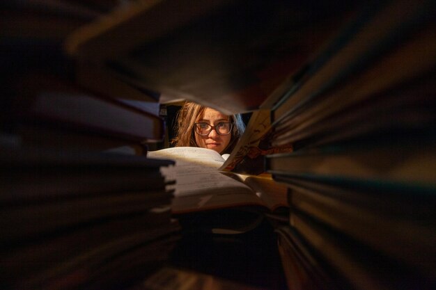 mujer bonita estudia rodeada de libros