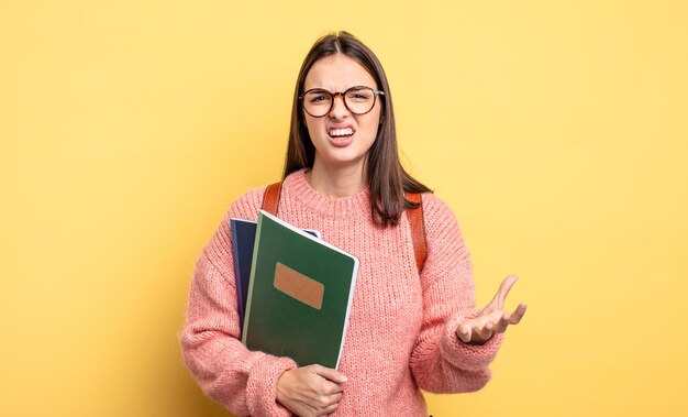 Mujer bonita estudiante que parece enojada, molesta y frustrada