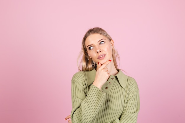 Mujer bonita europea en suéter casual en pared rosa