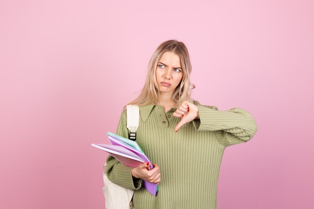 Mujer bonita europea en suéter casual en pared rosa