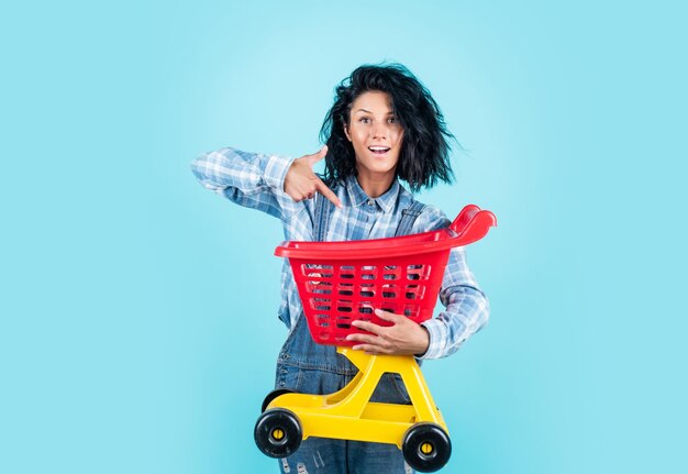 Mujer bonita feliz con cabello moreno usar ropa casual llevar venta de carrito de compras