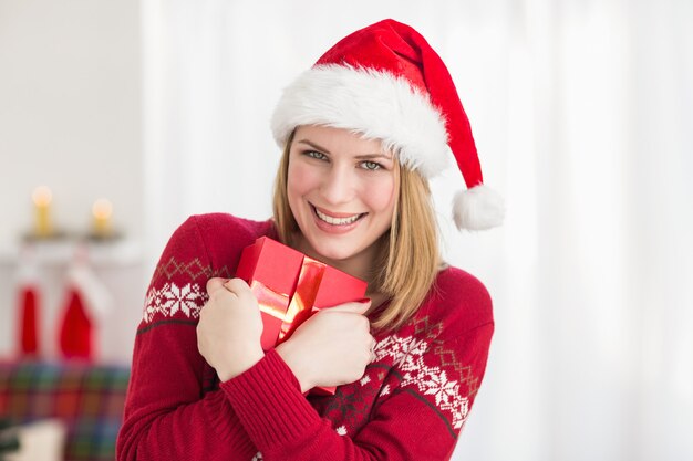 Mujer bonita festiva abrazando su regalo