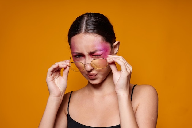 Mujer bonita gafas de moda maquillaje de cara rosa posando mirada atractiva fondo aislado inalterado