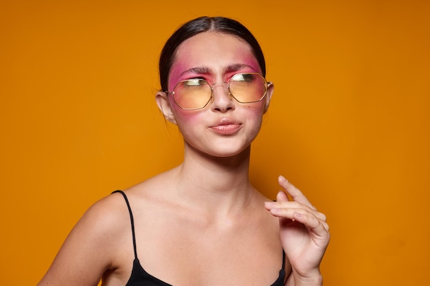 Mujer bonita gafas de moda maquillaje de cara rosa posando mirada atractiva fondo aislado inalterado