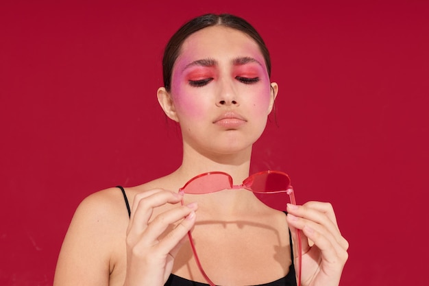 Mujer bonita en gafas rosas maquillaje emociones cosméticos fondo aislado inalterado