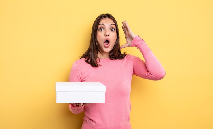 Foto mujer bonita gritando con las manos en el aire. concepto de embalaje de caja blanca