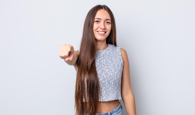 Mujer bonita hispana apuntando a la cámara con una sonrisa satisfecha, confiada y amistosa, eligiéndote