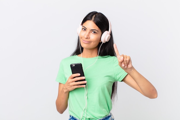 Mujer bonita hispana con auriculares y un smarphone