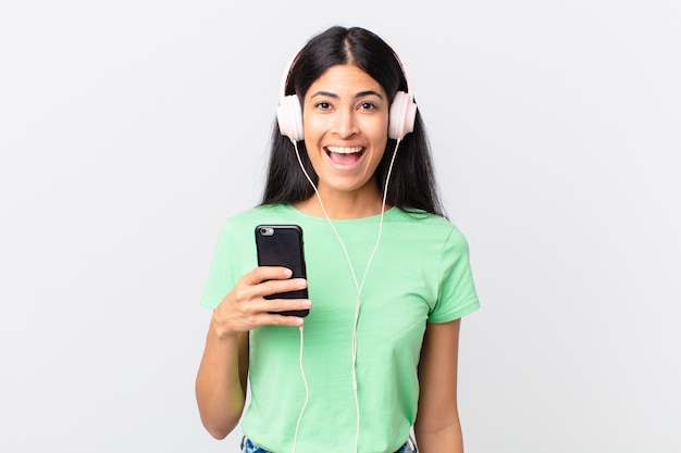 Mujer bonita hispana con auriculares y un smarphone