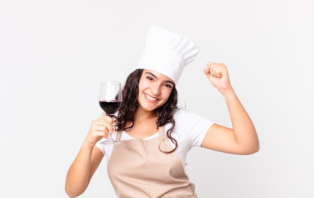 Mujer bonita hispana chef sosteniendo una copa de vino