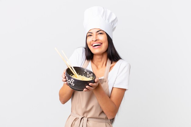 Mujer bonita hispana chef sosteniendo un tazón de fideos