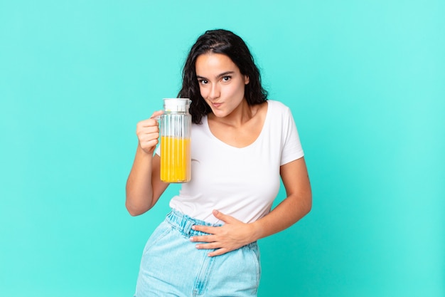 Mujer bonita hispana del cocinero. concepto de jugo de naranja