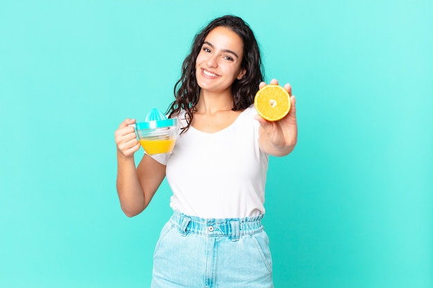 Mujer bonita hispana del cocinero. concepto de jugo de naranja