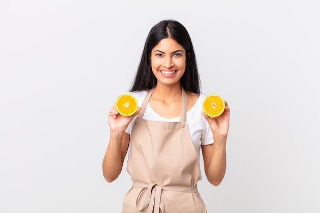 Mujer bonita hispana del cocinero. jugo de naranja y concepto de desayuno