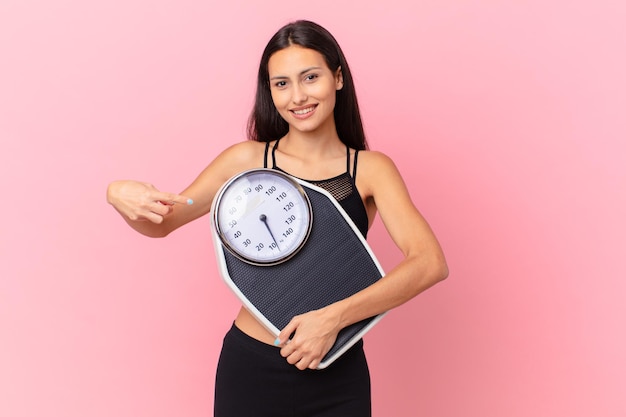 Mujer bonita hispana con una escala. concepto de dieta