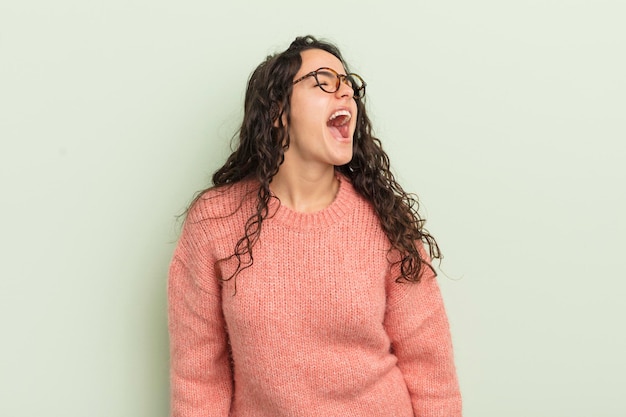 Foto mujer bonita hispana gritando furiosamente, gritando agresivamente, luciendo estresada y enojada