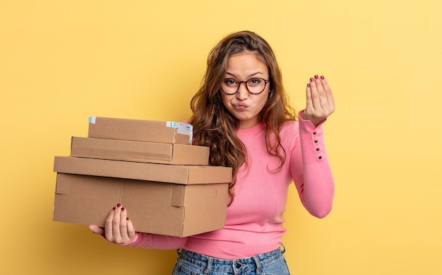 Mujer bonita hispana haciendo capice o gesto de dinero, diciéndole que pague. concepto de almacenamiento