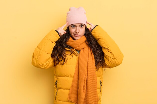 Mujer bonita hispana con una mirada seria y concentrada haciendo lluvia de ideas y pensando en un problema desafiante