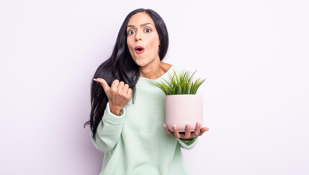 Mujer bonita hispana mirando asombrado con incredulidad. concepto de planta de casa