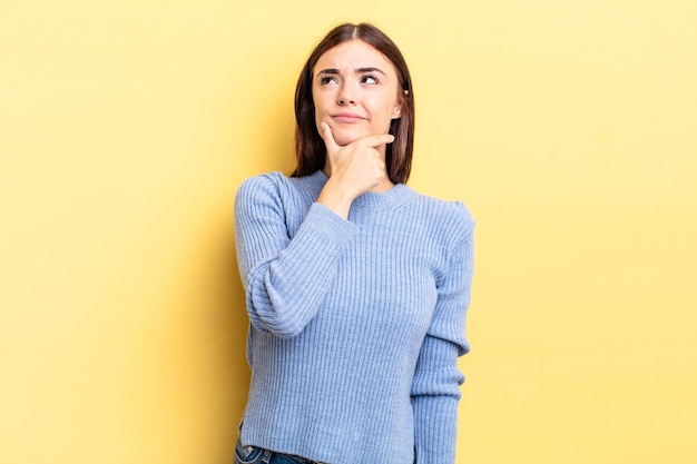 Mujer bonita hispana pensando sintiéndose dudosa y confundida con diferentes opciones preguntándose qué decisión tomar