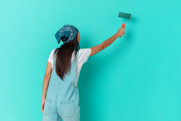 Foto mujer bonita hispana pintando una pared