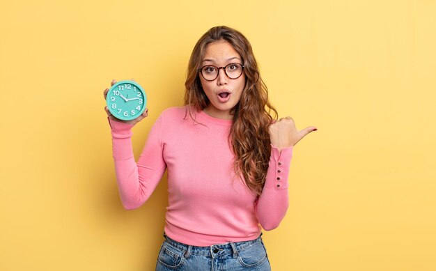 Mujer bonita hispana que parece asombrada por el concepto de despertador de incredulidad