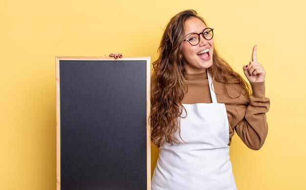 Mujer bonita hispana que se siente como un genio feliz y emocionado después de darse cuenta de una idea. concepto de espacio de copia de pizarra