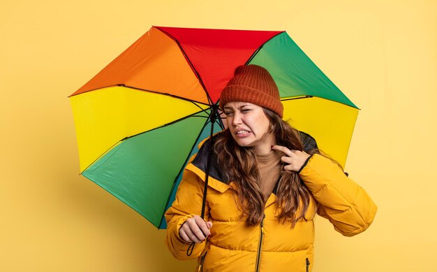 Mujer bonita hispana que se siente estresada, ansiosa, cansada y frustrada. concepto de paraguas