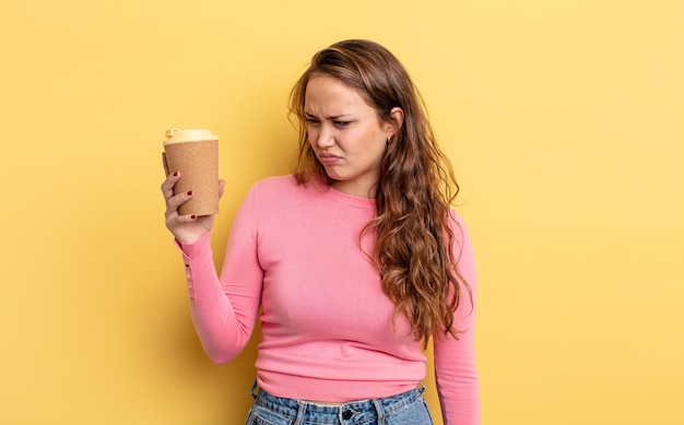 Mujer bonita hispana que se siente triste, molesta o enojada y mira hacia un lado. concepto de café para llevar