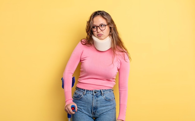 Mujer bonita hispana que se siente triste, molesta o enojada y mirando hacia un lado. accidente de muleta y collar