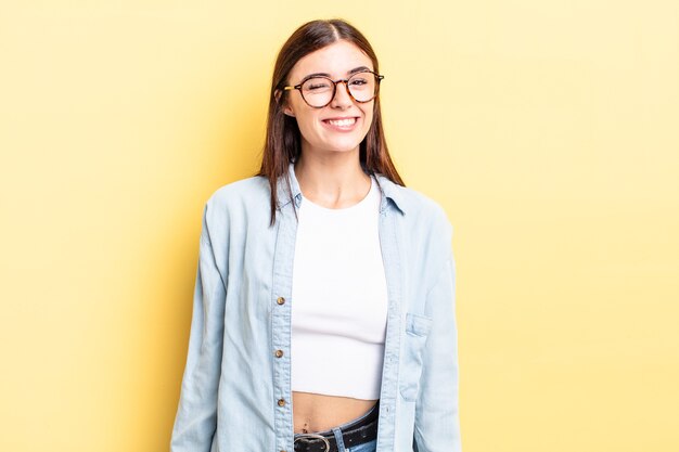 Foto mujer bonita hispana que se ve feliz y amigable, sonriendo y guiñando un ojo con una actitud positiva