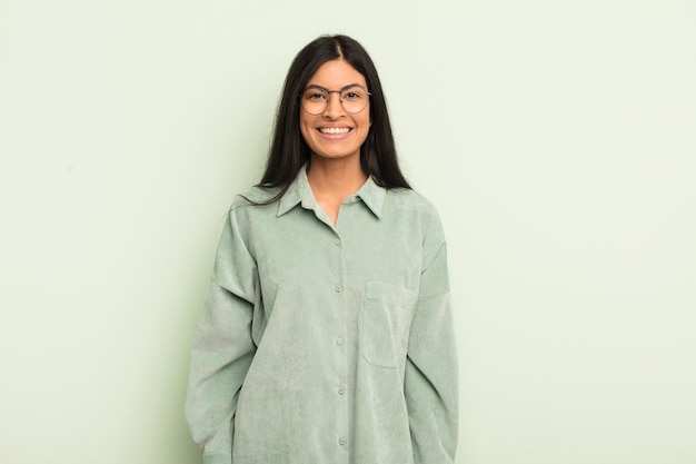 Mujer bonita hispana que se ve feliz y tonta con una sonrisa amplia, divertida y loca y los ojos bien abiertos