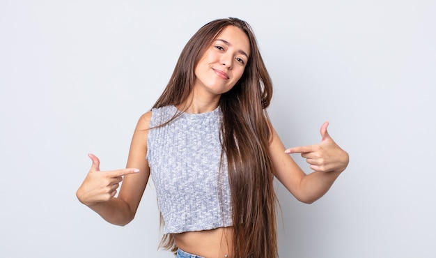 Mujer bonita hispana que se ve orgullosa, arrogante, feliz, sorprendida y satisfecha, señalando a sí misma, sintiéndose como una ganadora