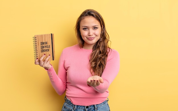 Mujer bonita hispana sonriendo felizmente con amable y ofreciendo y mostrando un concepto. concepto de reciclaje