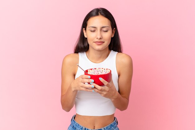 Mujer bonita hispana con un tazón de desayuno con hojuelas