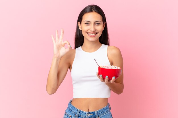 Mujer bonita hispana con un tazón de desayuno con hojuelas