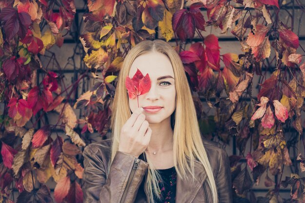 Mujer bonita con hojas de otoño