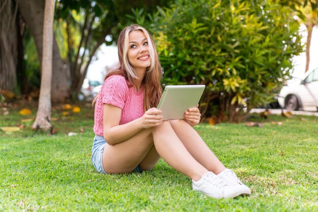 Mujer bonita joven al aire libre escuchando música con el móvil y feliz