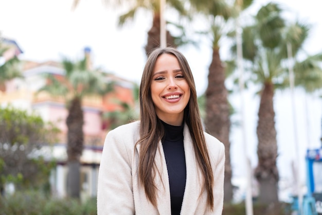 Mujer bonita joven al aire libre con expresión feliz