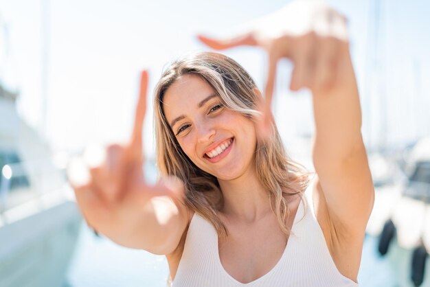 Mujer bonita joven al aire libre con expresión feliz