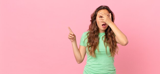 Mujer bonita joven y apuntando al espacio de la copia