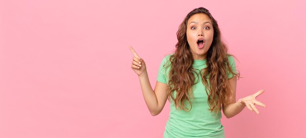 Mujer bonita joven y apuntando al espacio de la copia