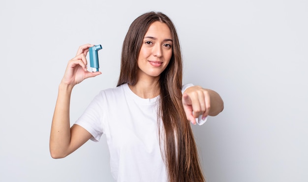 Mujer bonita joven apuntando a la cámara eligiéndote. concepto de asma