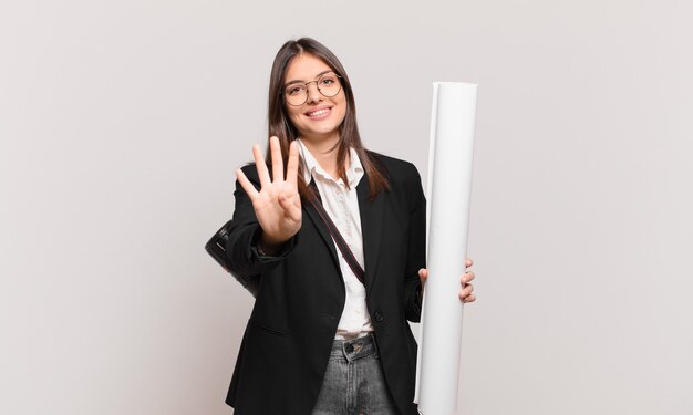 Mujer bonita joven arquitecto sonriendo y mirando amigable, mostrando el número cuatro o cuarto con la mano hacia adelante, contando hacia atrás