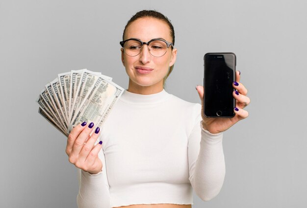 Foto mujer bonita joven con billetes de dólar y un teléfono inteligente